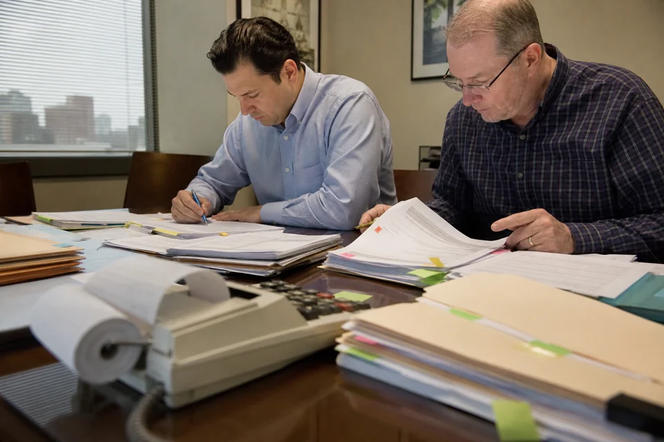 CPA office conference table covered with client folders during tax season