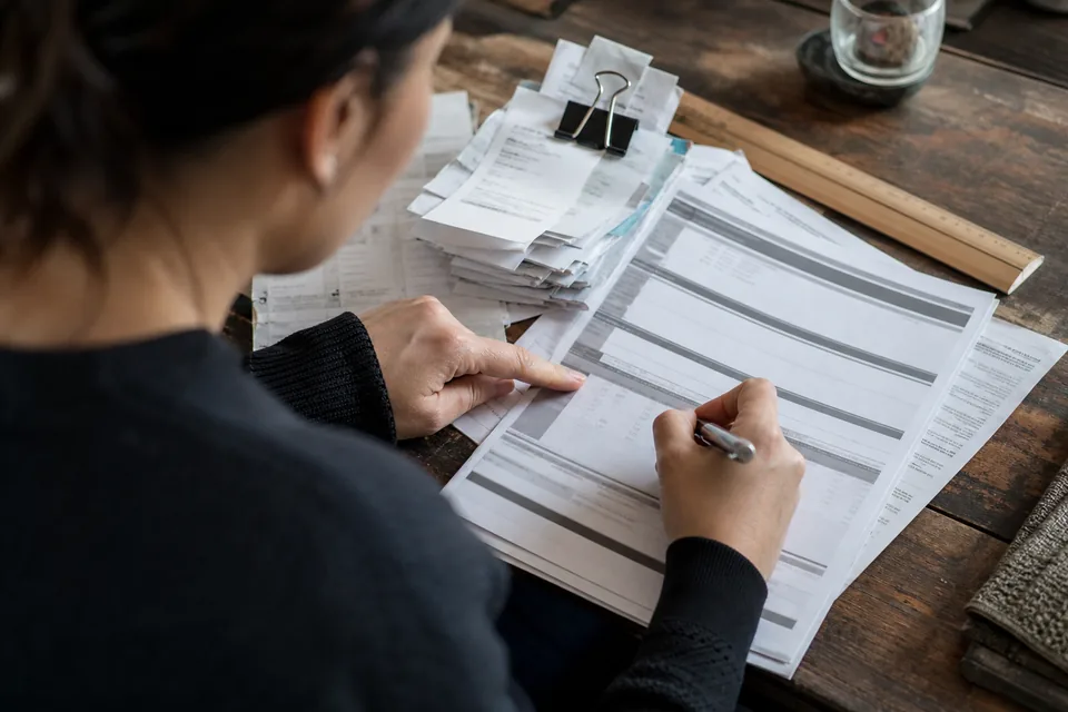 Credit card statement printout with receipts clipped beside it