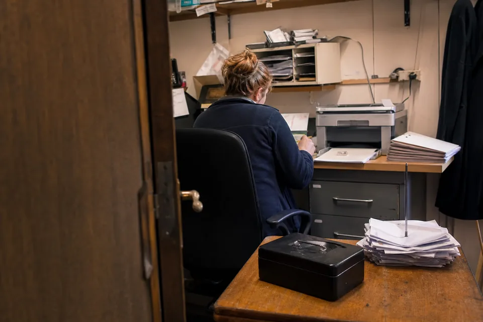 Small business back office desk with bank statements and invoices